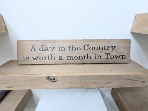 a day in the country is worth a month in town sign on a bench at Luxury Cabin in The Country With King Bed and Loft #1 in Point