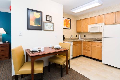 a kitchen with a table and chairs in a room at Residence Inn by Marriott Baton Rouge near LSU in Baton Rouge