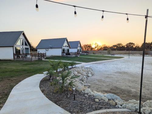 a path leading to a house with the sunset in the background at Luxury Cabin in The Country With King Bed and Loft #1 in Point