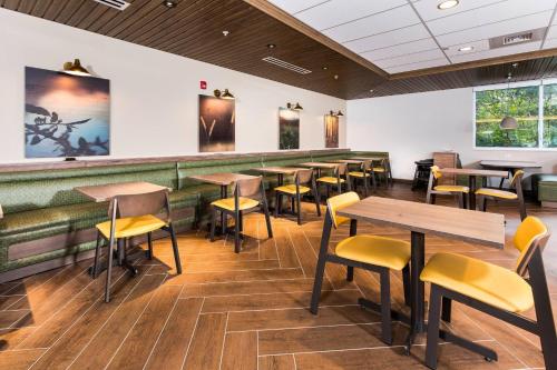 a restaurant with wooden tables and yellow chairs at Fairfield Inn & Suites by Marriott Crestview in Crestview