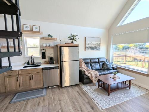 a kitchen and living room with a refrigerator and a couch at Luxury Cabin in The Country With King Bed and Loft #1 in Point