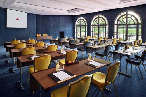 a large room with tables and chairs and windows at Fes Marriott Hotel Jnan Palace in Fès