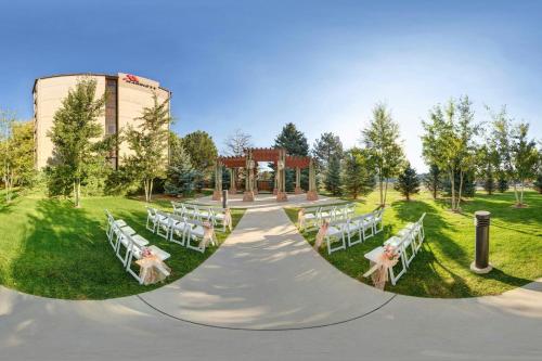 a wedding venue with white tables and chairs in the grass at Fort Collins Marriott in Fort Collins