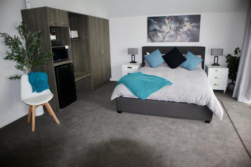 a bedroom with a large bed with blue pillows at Third St Studio in Christchurch