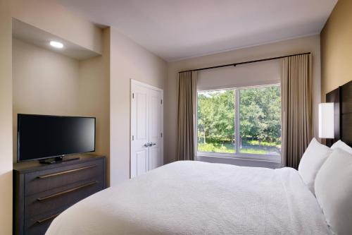 a bedroom with a bed and a tv and a window at Residence Inn by Marriott Brunswick in Brunswick