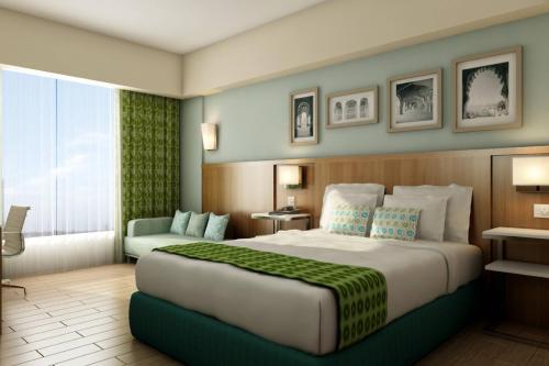a hotel room with a large bed and a chair at Fairfield by Marriott Visakhapatnam in Visakhapatnam