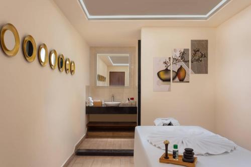 a room with a bed and a bathroom with a sink at Fairfield by Marriott Visakhapatnam in Visakhapatnam