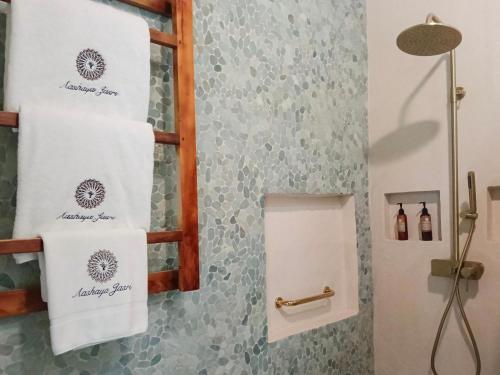 a bathroom with two towels hanging on a wall at Aashaya Jasri Resort in Jasri