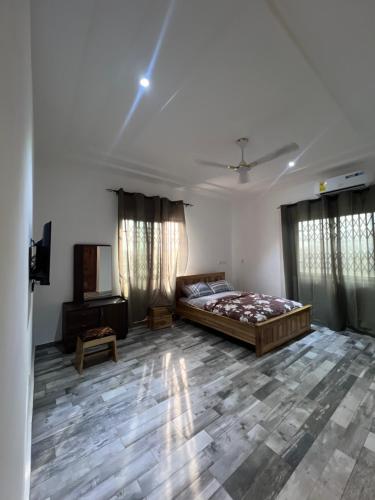 a bedroom with a bed and a television in it at Citrus Duplex Getaway in Dawhwenya