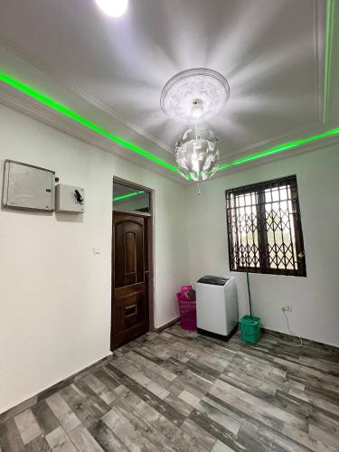 an empty room with green lights on the ceiling at Citrus Duplex Getaway in Dawhwenya
