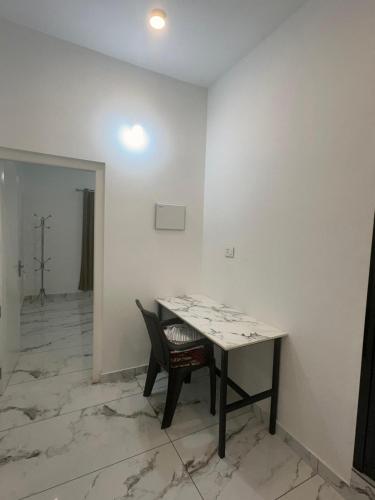 a room with a table and a chair in it at Homie Hub in Meppādi
