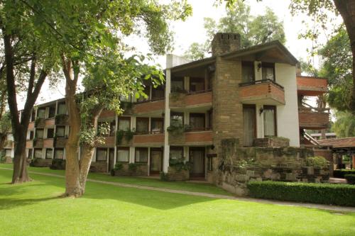 a large brick building with a tree in front of it at Marriott Puebla Hotel Meson del Angel in Puebla