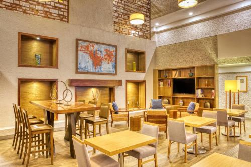 a dining room with tables and chairs and a tv at Marriott Puebla Hotel Meson del Angel in Puebla