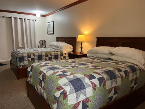 a bedroom with two beds and a table with a lamp at Arthur Country Inn in Arthur