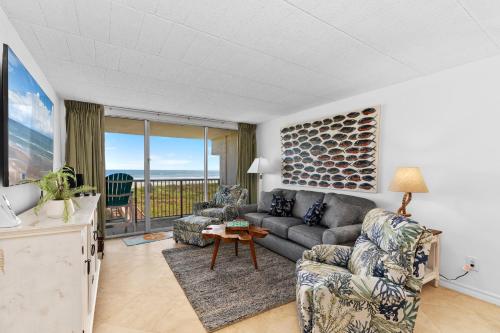 una sala de estar con un sofá y una mesa en Breakers Condo Unit #307, en South Padre Island