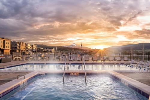 a large swimming pool with a sunset in the background at Residence Inn by Marriott Big Sky/The Wilson Hotel in Big Sky