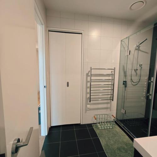a bathroom with a shower and a glass door at Auckland Birkenhead BNB in Auckland