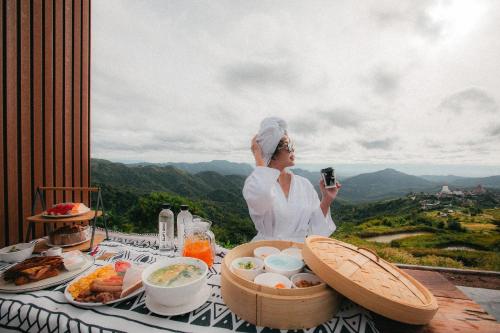 een vrouw die een foto neemt van een tafel met eten bij The Pino Khao Kho in Phetchabun