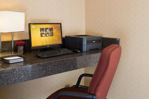 a desk with a computer and a monitor and a chair at Residence Inn Canton in North Canton
