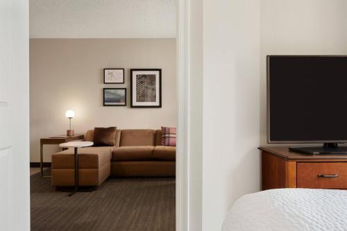 a living room with a couch and a flat screen tv at Residence Inn Baltimore White Marsh in Baltimore