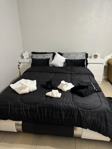 a black bed with two white towels on it at Sunshine guesthouse in Mulberry