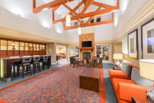 a large living room with orange furniture and a fireplace at Residence Inn Baltimore White Marsh in Baltimore