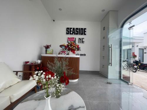 a living room with a couch and a table with flowers at Seaside Mui Ne Hotel in Mui Ne