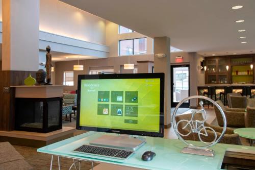 a computer monitor on a glass table with a keyboard and mouse at Residence Inn by Marriott Akron South/Green in Akron