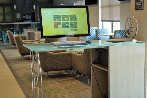 a computer monitor sitting on a desk with chairs at Residence Inn by Marriott Akron South/Green in Akron