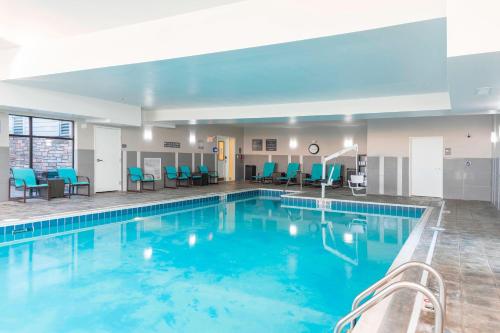 a pool in a hotel room with blue chairs at Residence Inn by Marriott Akron South/Green in Akron