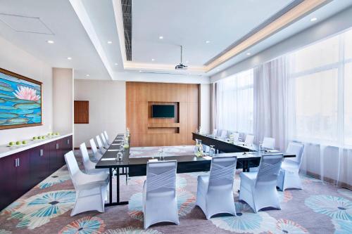 a conference room with a long table and white chairs at Guyana Marriott Hotel Georgetown in Georgetown