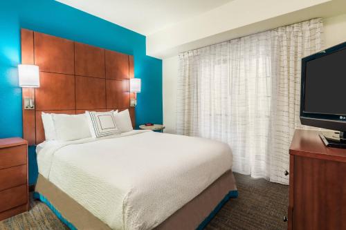 a hotel room with a bed and a flat screen tv at Residence Inn Chattanooga Downtown in Chattanooga