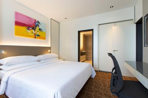 a bedroom with a white bed and a desk at Four Points by Sheraton Singapore, Riverview in Singapore