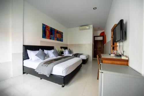 Ένα ή περισσότερα κρεβάτια σε δωμάτιο στο Sandat Hotel Legian