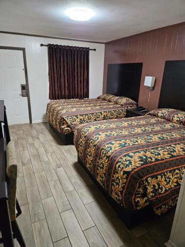 a hotel room with two beds in a room at Traveler's Inn in Roanoke