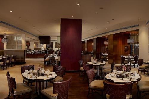 a dining room with tables and chairs in a restaurant at ITC Maurya, a Luxury Collection Hotel, New Delhi in New Delhi
