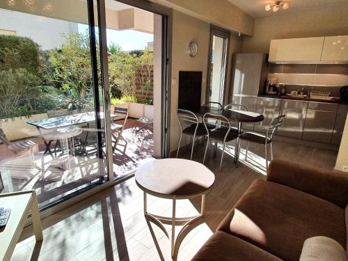 Il comprend un salon avec un canapé et des tables ainsi qu'une cuisine. dans l'établissement Studio avec Coin-Nuit, Terrasse et Parking, Centre Sainte-Maxime, Proche Plages - 4 Pers. - FR-1-780-61, à Sainte-Maxime