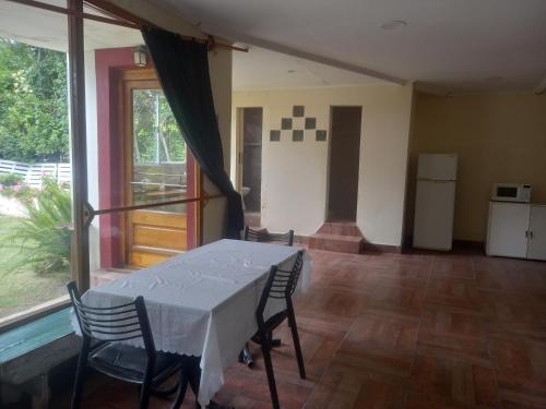 Un comedor con mesa y sillas y una ventana. en El jardín, en General Juan Madariaga
