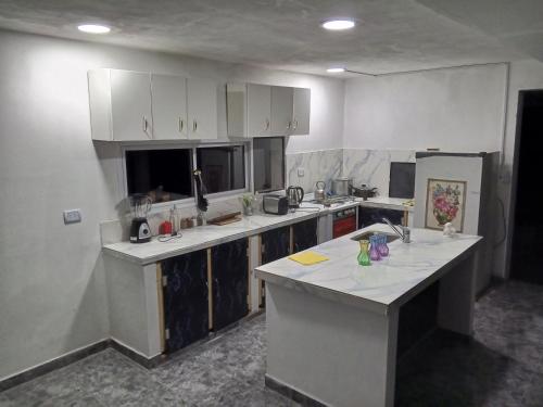 タフィ・デル・バジェにあるCasa hauseの白いキャビネットとカウンタートップを備えたキッチン