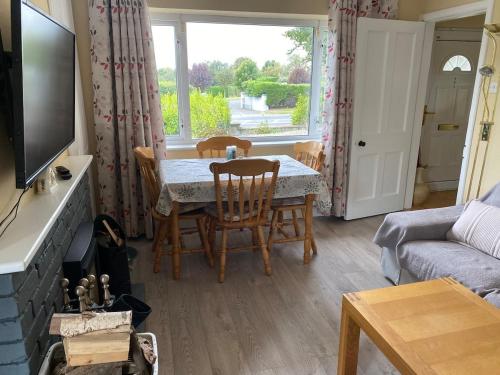 a living room with a table and chairs and a window at An Teach Tykillen Cosy Home in Limerick