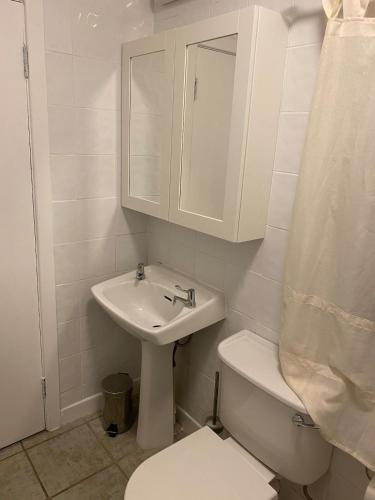 a white bathroom with a sink and a toilet at An Teach Tykillen Cosy Home in Limerick