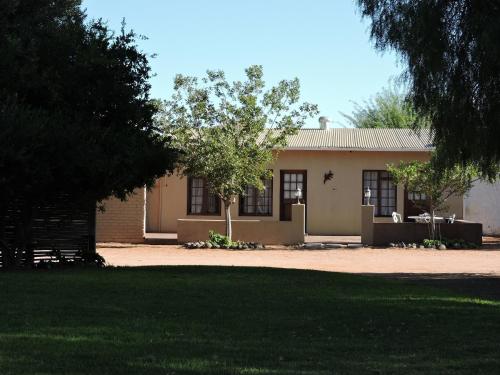 a house with a tree in front of it at Savanna Guest Farm in Grünau