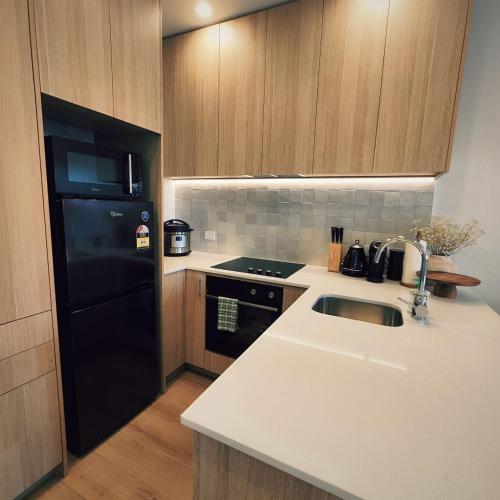 a kitchen with a sink and a black refrigerator at Auckland Ellerslie House in Auckland