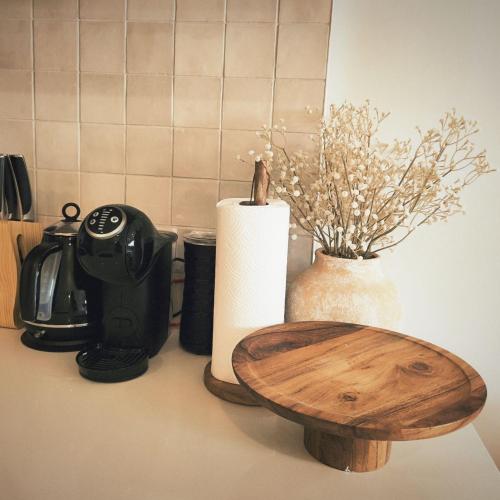 a counter top with a coffee pot and a wooden table at Auckland Ellerslie House in Auckland
