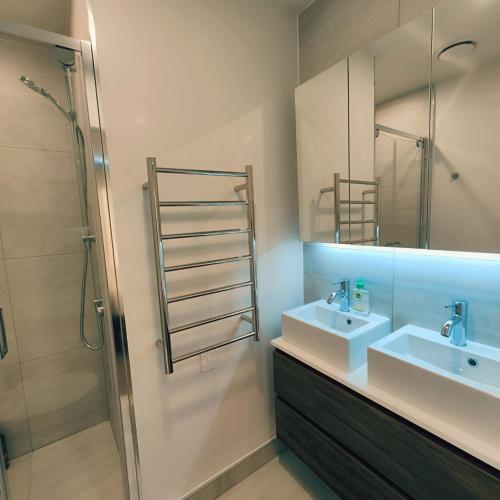 a bathroom with a sink and a shower at Auckland Ellerslie House in Auckland