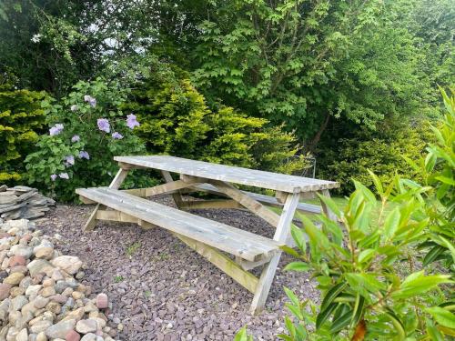 a wooden picnic table sitting in a garden at Dromane Lodge self-catering apartment eircode V94HR5C in Limerick