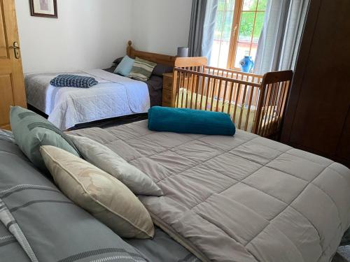 a bedroom with two beds and a crib at Dromane Lodge self-catering apartment eircode V94HR5C in Limerick
