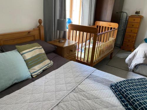 a bedroom with a bed and a crib and a crib at Dromane Lodge self-catering apartment eircode V94HR5C in Limerick