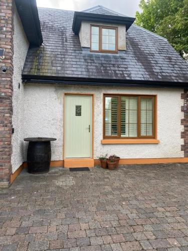 a white house with a white door and windows at Dromane Lodge self-catering apartment eircode V94HR5C in Limerick