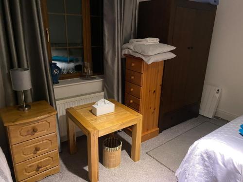 a bedroom with a dresser and a table with a bed at Dromane Lodge self-catering apartment eircode V94HR5C in Limerick